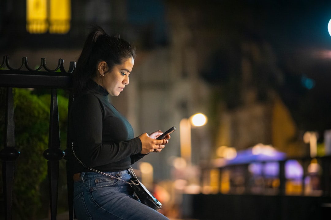 woman using smartphone dating app at night
