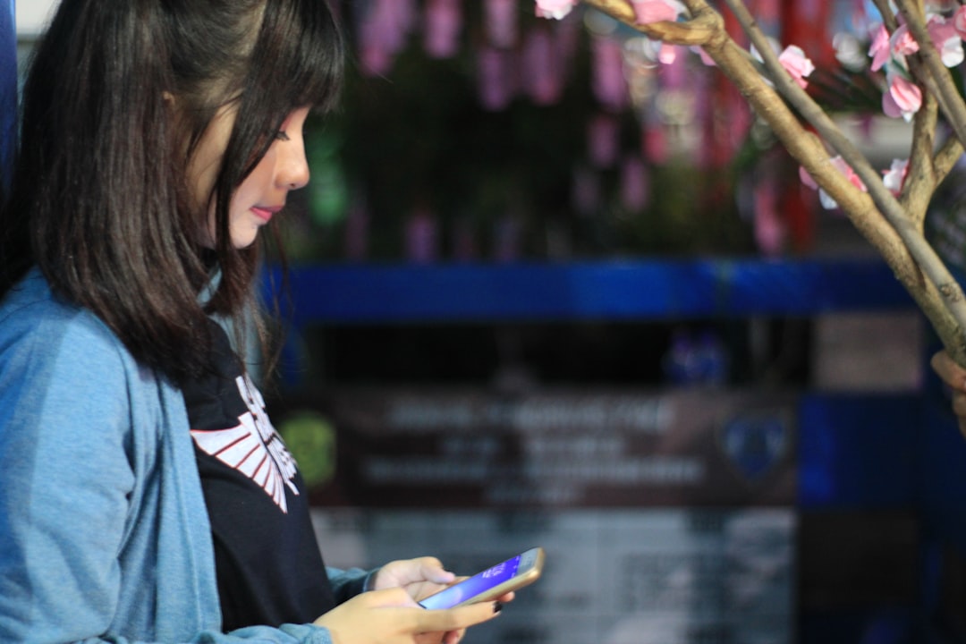 smiling japanese woman using smartphone