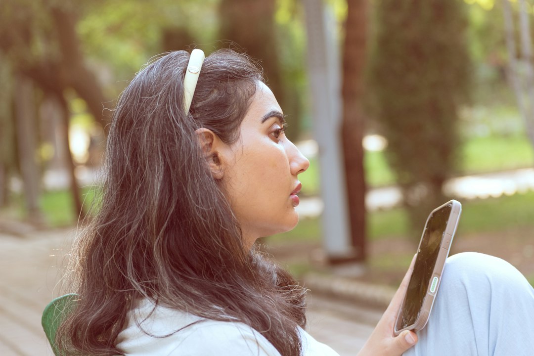 young woman looking worried at smartphone screen