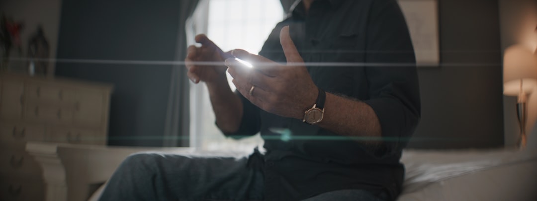man texting on phone late night warm light bedroom