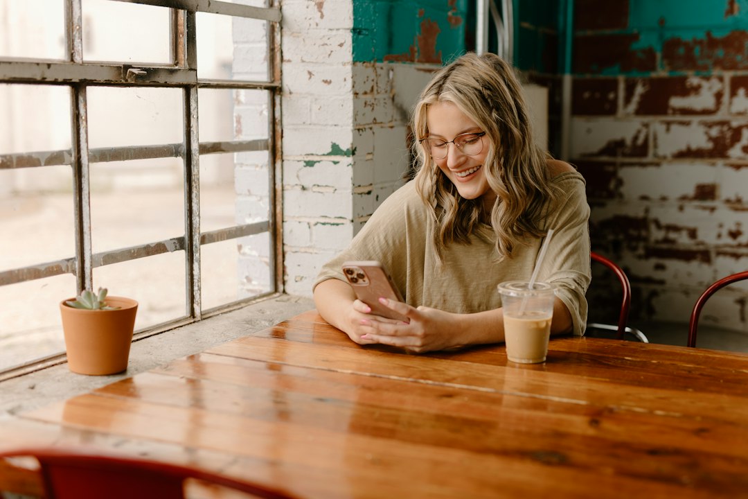 typing message on phone coffee shop