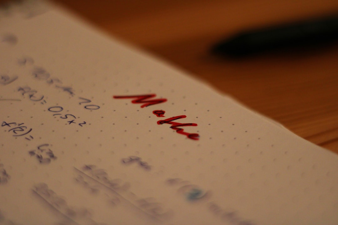 red pen crossing out text on paper