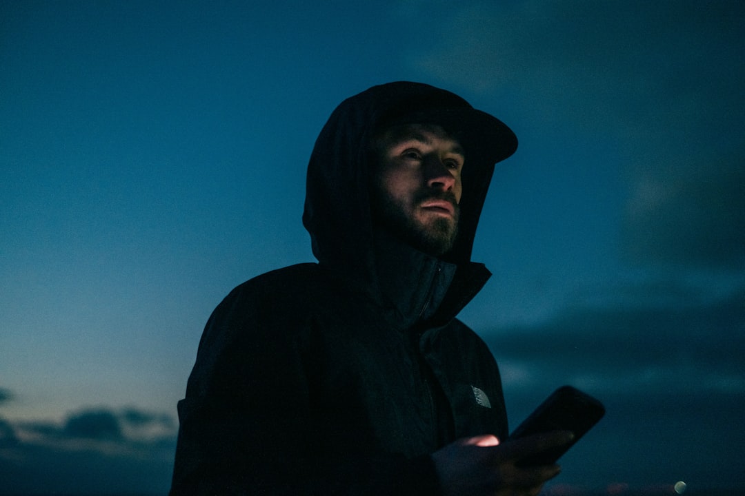 man looking at smartphone alone at night