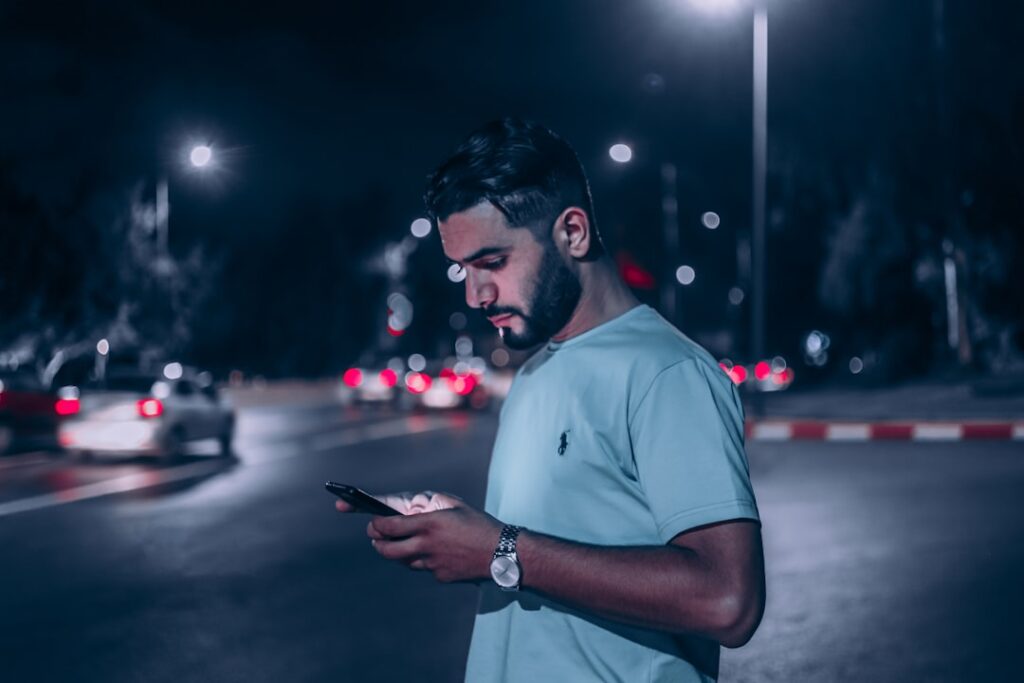 man texting on smartphone at night