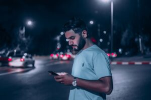 man texting on smartphone at night