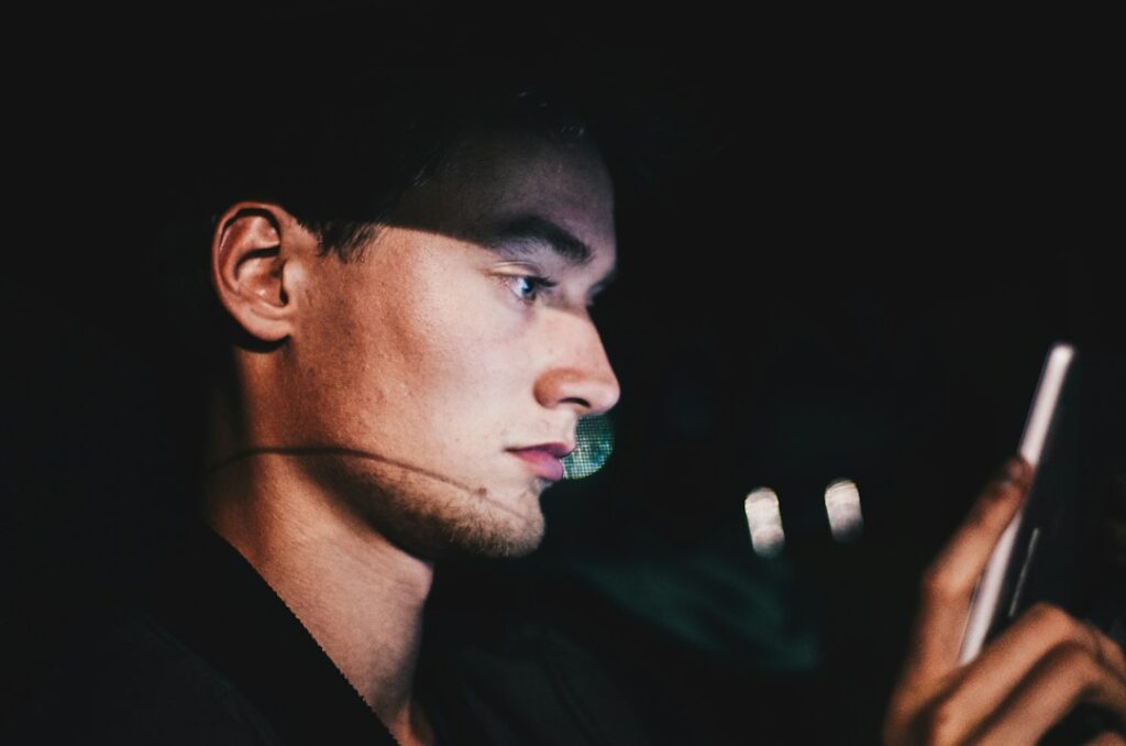 man using smartphone alone at night