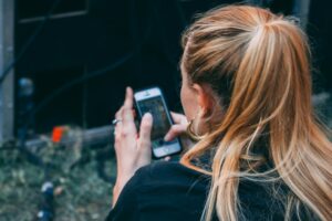 woman looking at smartphone dating app profile