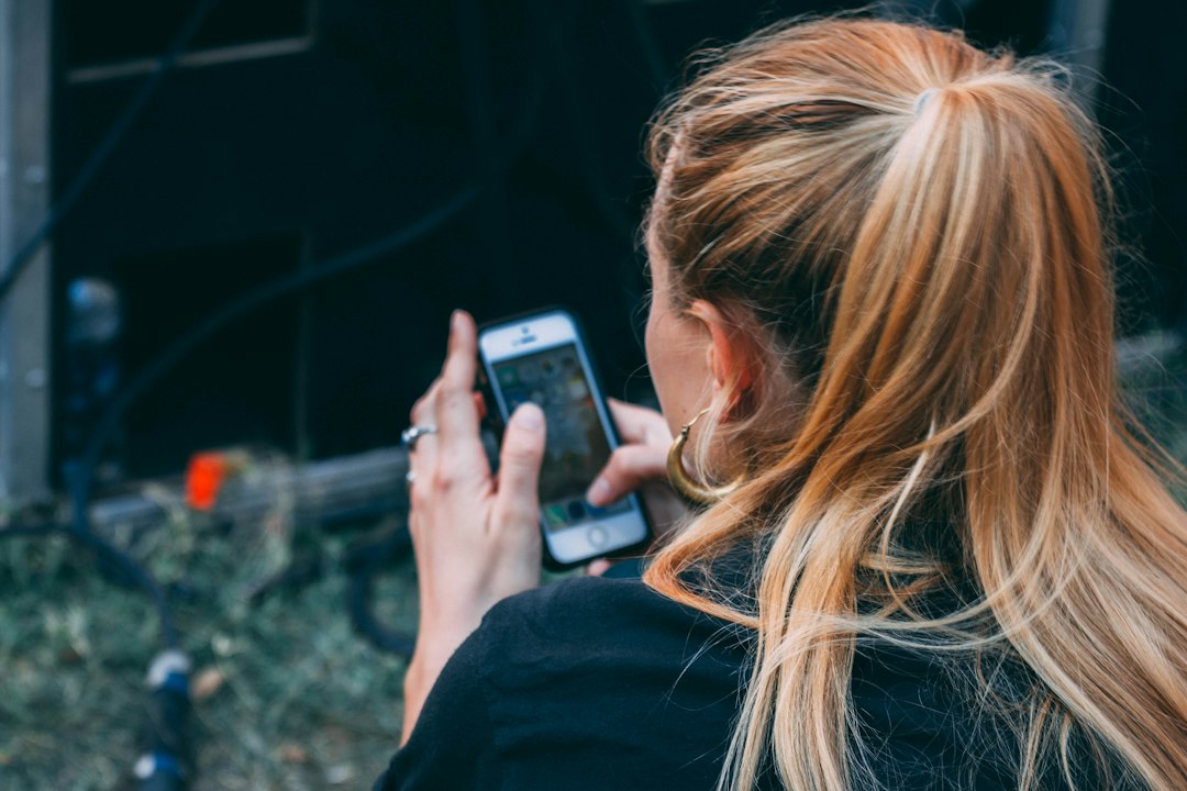 woman looking at smartphone dating app profile