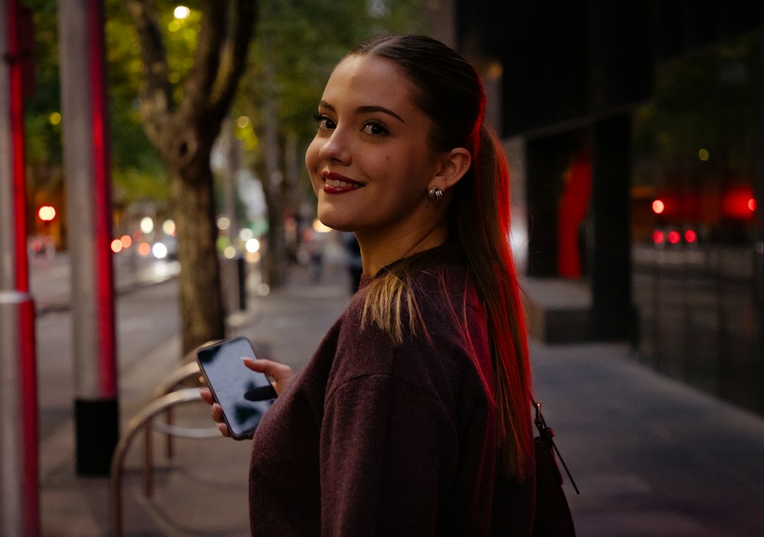 woman looking at smartphone dating app night