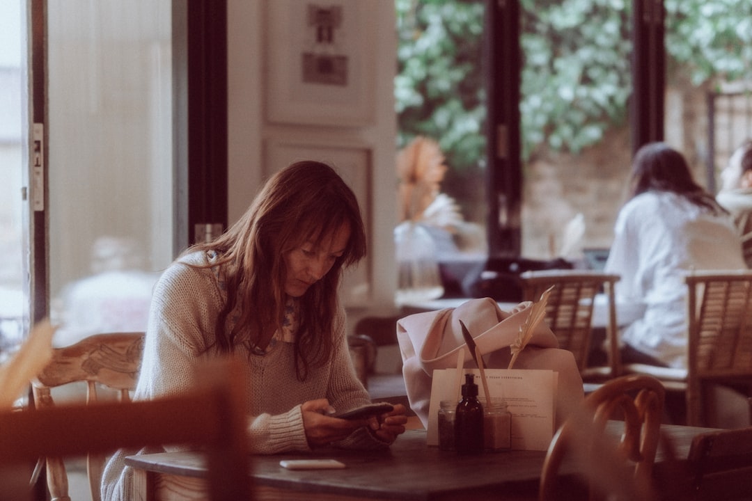 woman checking smartphone messages cafe