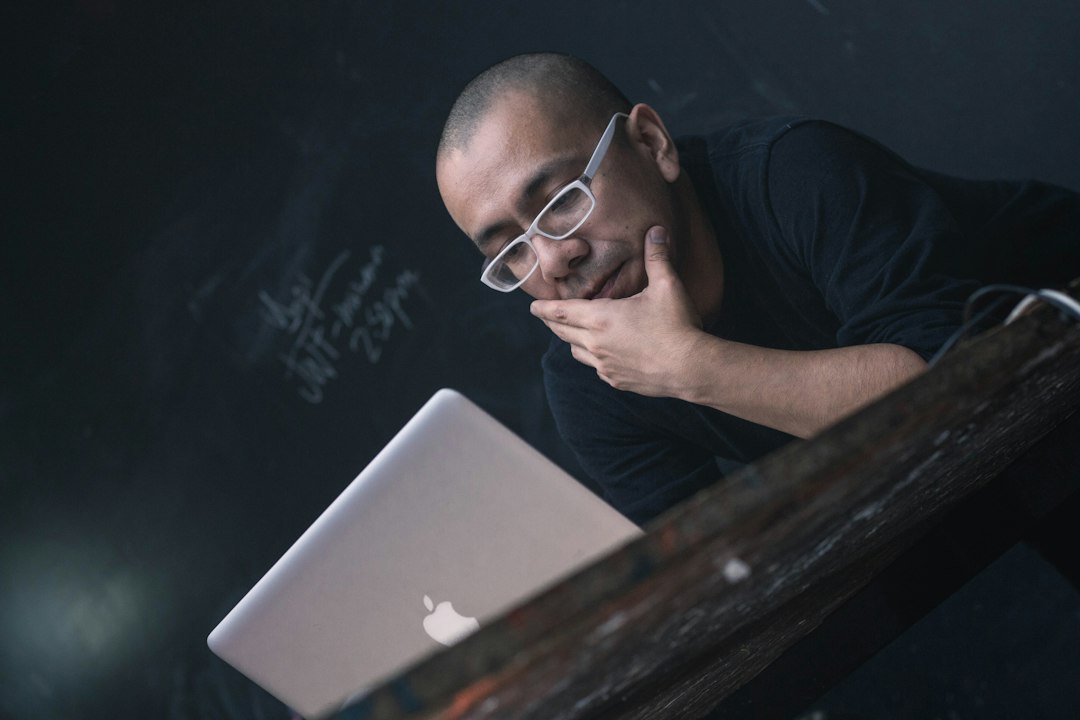 man thinking in front of laptop at night
