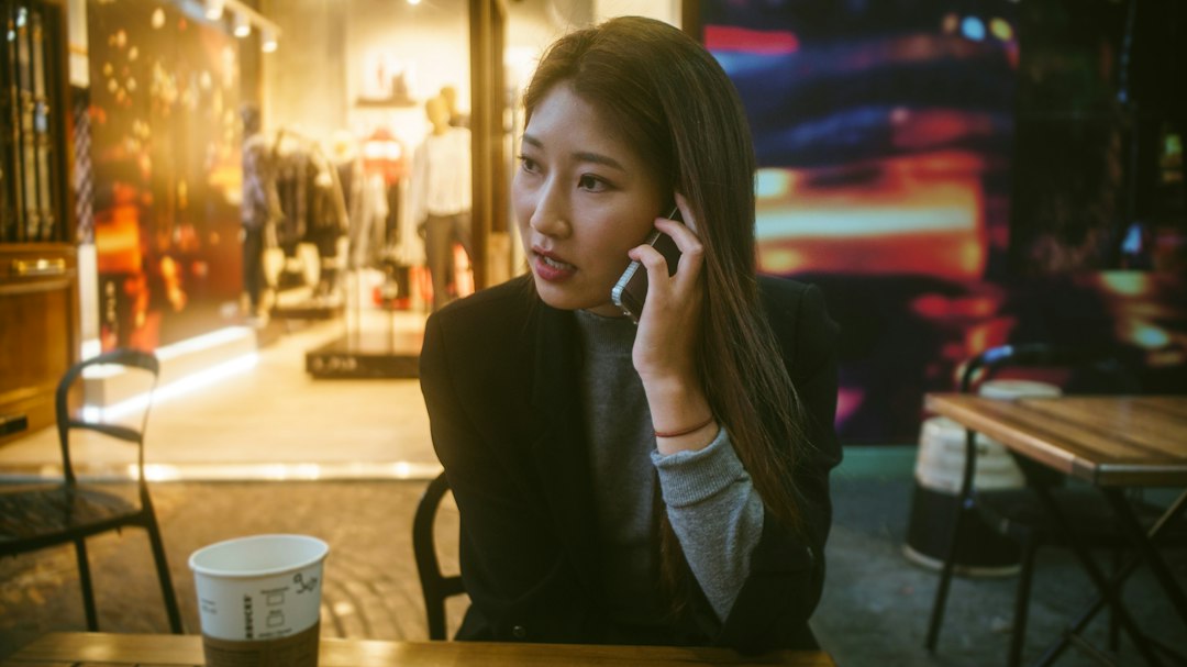 woman looking at smartphone cafe worried
