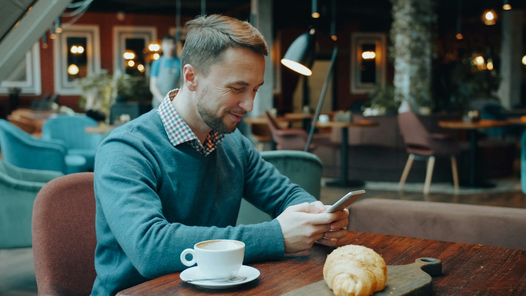 person texting on smartphone cafe
