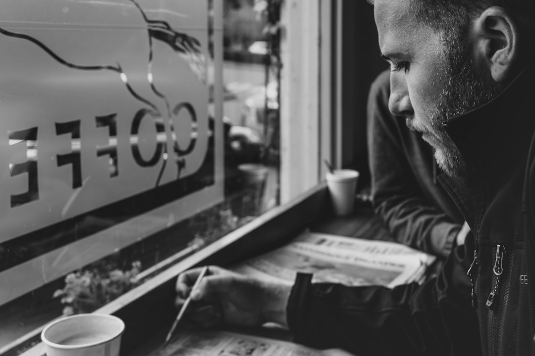man reflecting coffee window