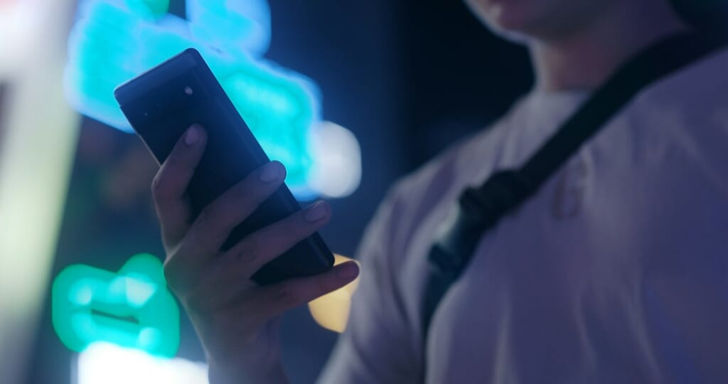 man using dating app on smartphone at night