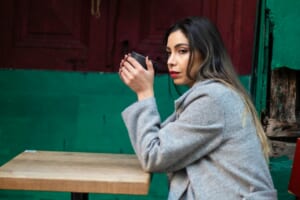 woman looking at smartphone worried cafe